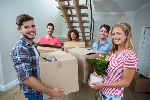 A local packing team organising boxes in a Chalkfarm home with narrow access